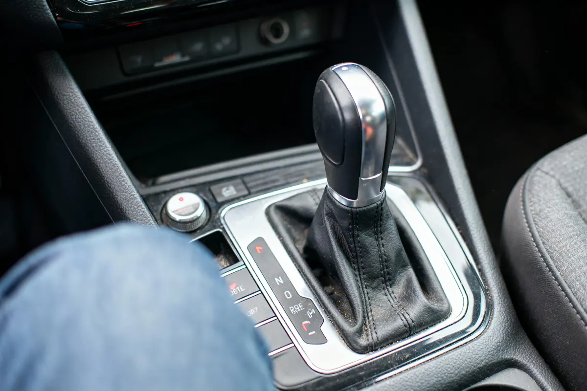 Levier de vitesse automatique dans une voiture, avec intérieur en cuir noir et détails chromés.
