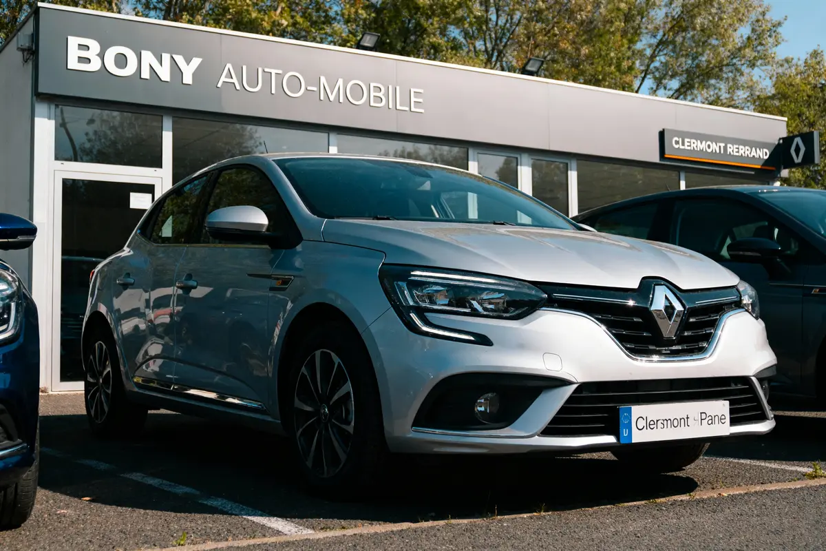 Voiture Renault grise stationnée devant concession Bony Auto-Mobile, Clermont-Ferrand, par une journée ensoleillée.