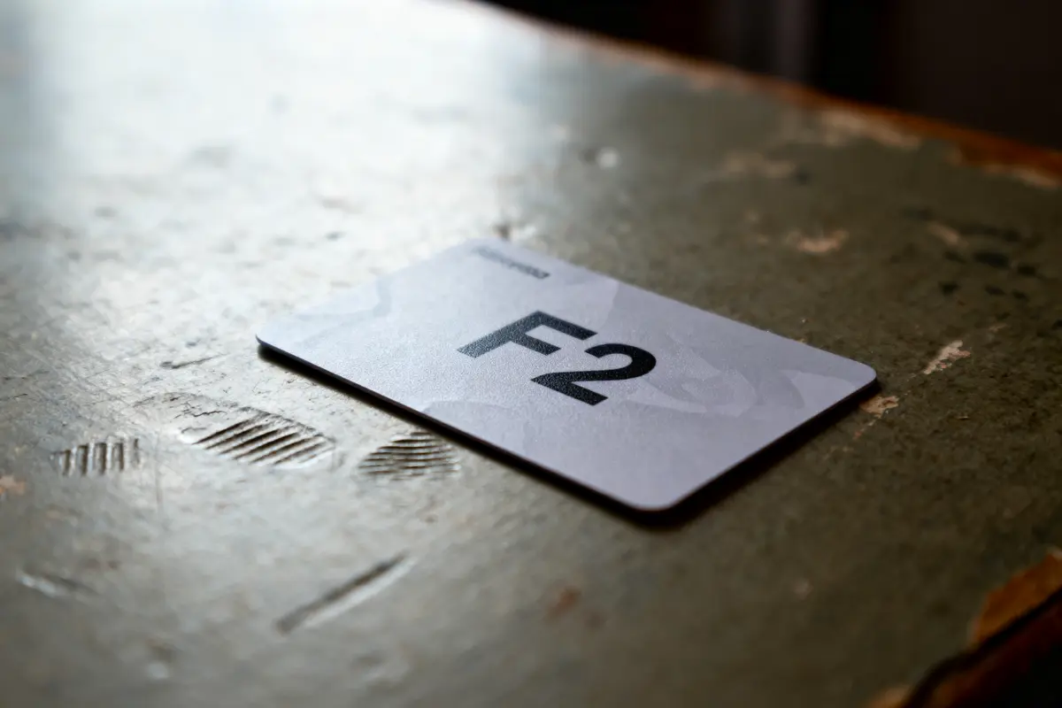 Carte grise "F2" posée sur table en bois usée avec marques.