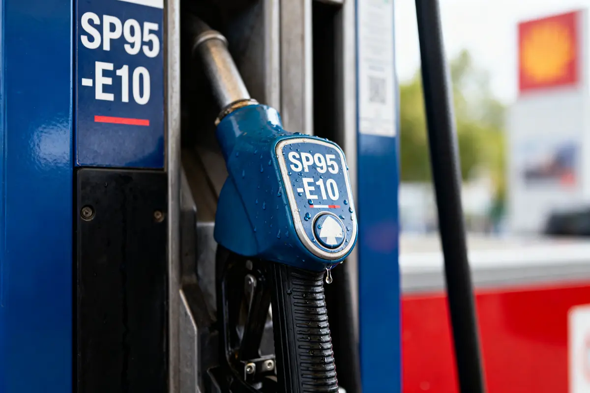 Pompe à essence SP95-E10 bleue avec gouttes d'eau dans une station-service.