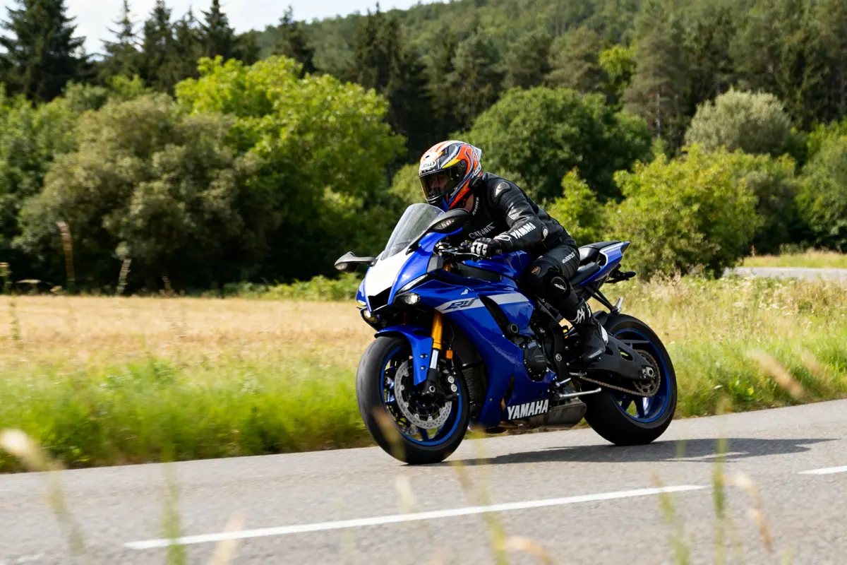 Motard en Yamaha R1 vitesse max sur route bordée d'arbres et de champs