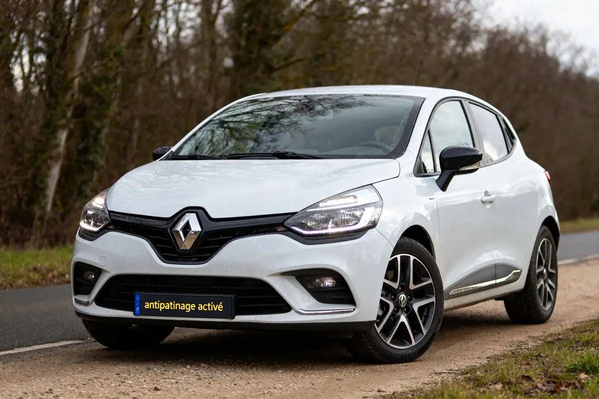 Renault Clio 4 blanche avec antipatinage activé stationnée en bordure de route rurale